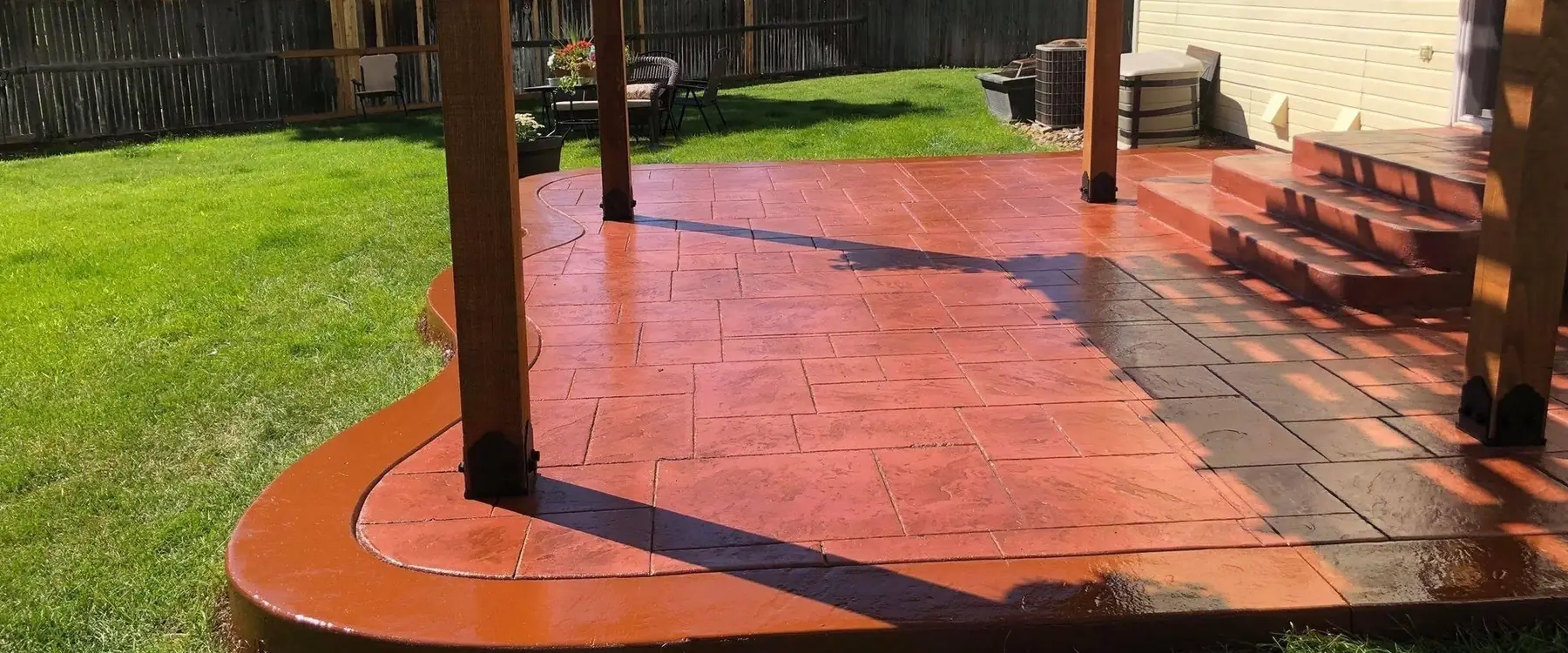 Terracotta stamped concrete patio and steps under a cedar pergola