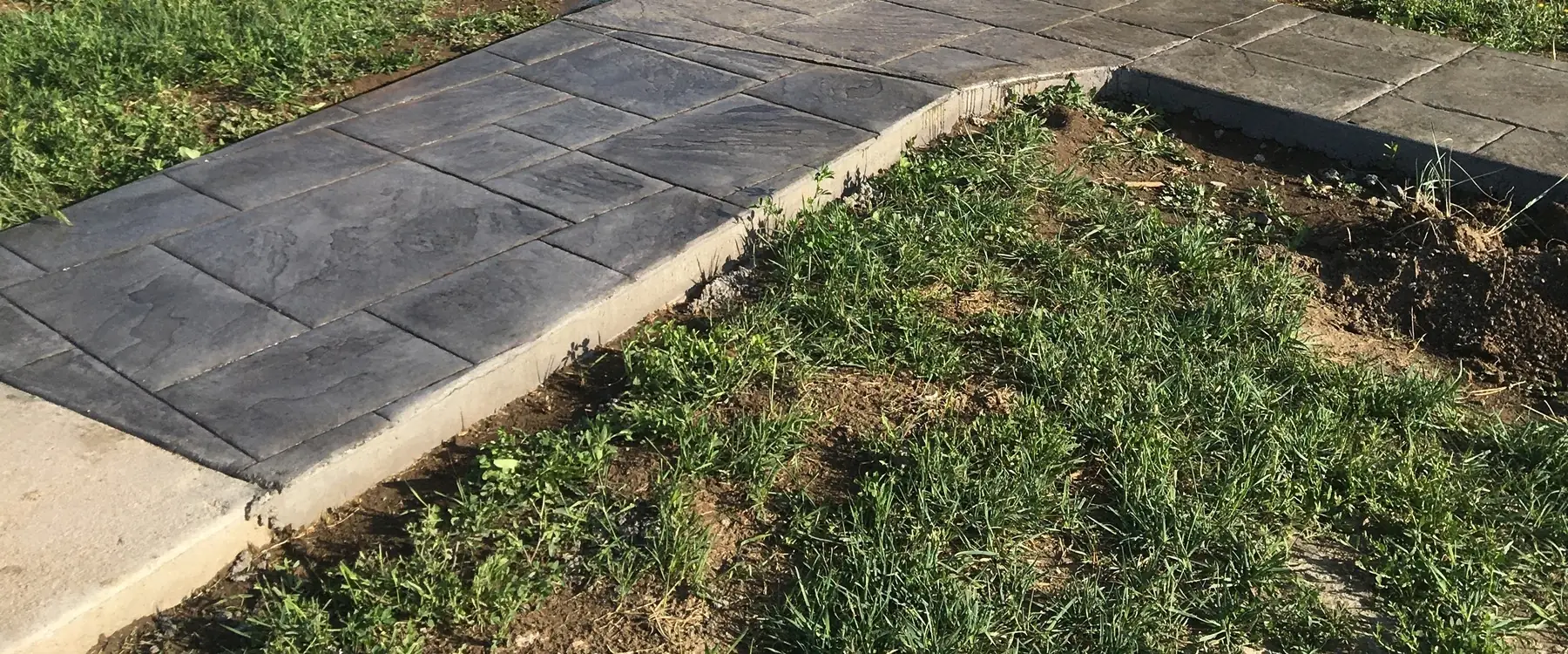 Stamped concrete walkway curving through a lawn