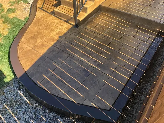 Wood-plank stamped patio beside a fence